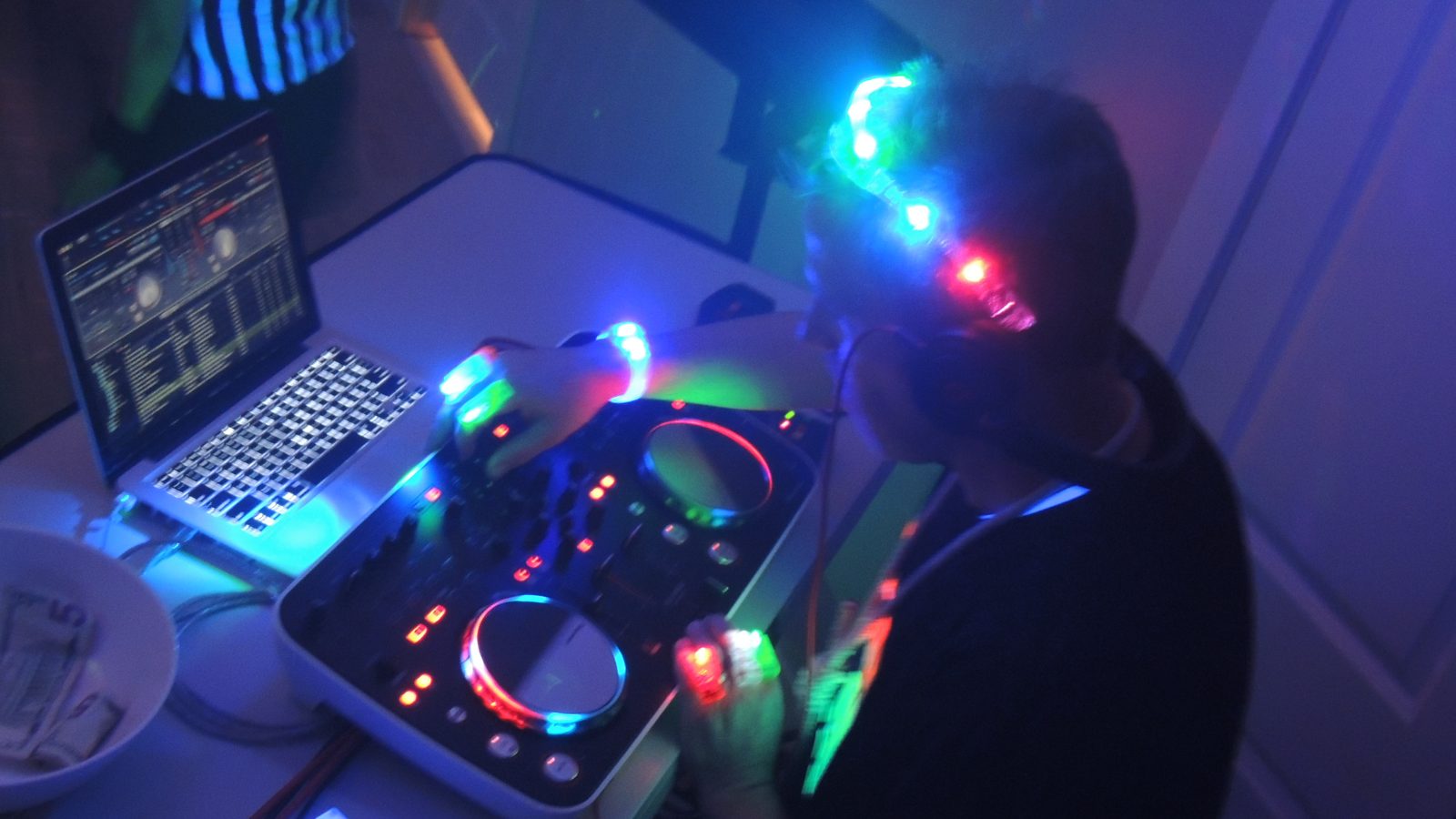 DJ Pitchshifter behind the decks under blue stage light